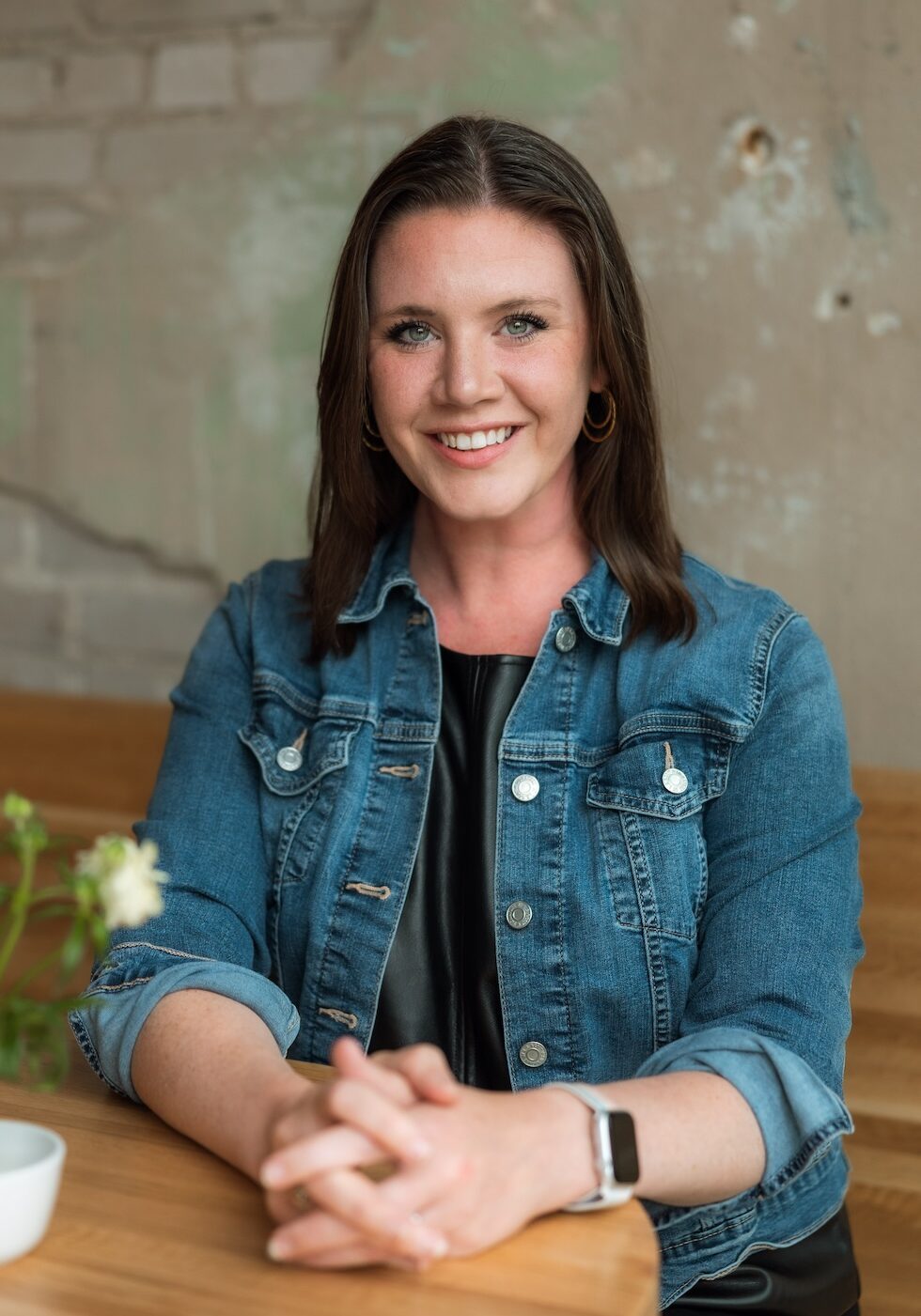 White woman in her thirties with brown hair smiling.